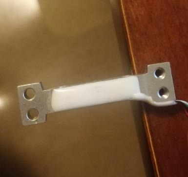 Load cell mounted at the edge of a table.
