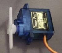 Photo of a servo motor with the plastic arm attachment fitted to the shaft.